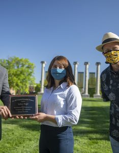 Jim Spain presents Hesburgh scholarship plaque to Sydney Boeger while William Horner stands by.