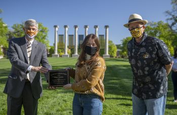 Jim Spain presents Hesburgh scholarship plaque to Maggie Courtney while William Horner stands by.