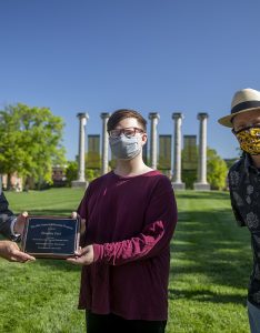Jim Spain presents Hesburgh scholarship plaque to Brandon Ford while William Horner stands by.