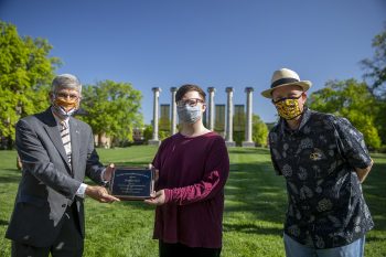 Jim Spain presents Hesburgh scholarship plaque to Brandon Ford while William Horner stands by.