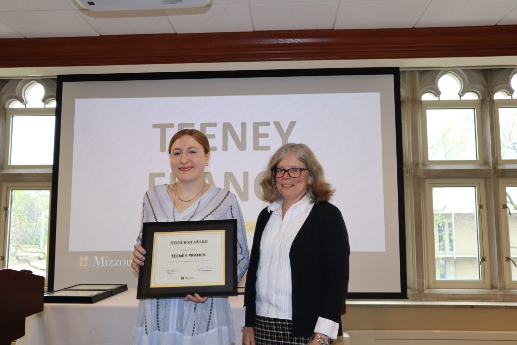 Teeney Franck holding certificate at awards ceremony with Dr. Monnier.
