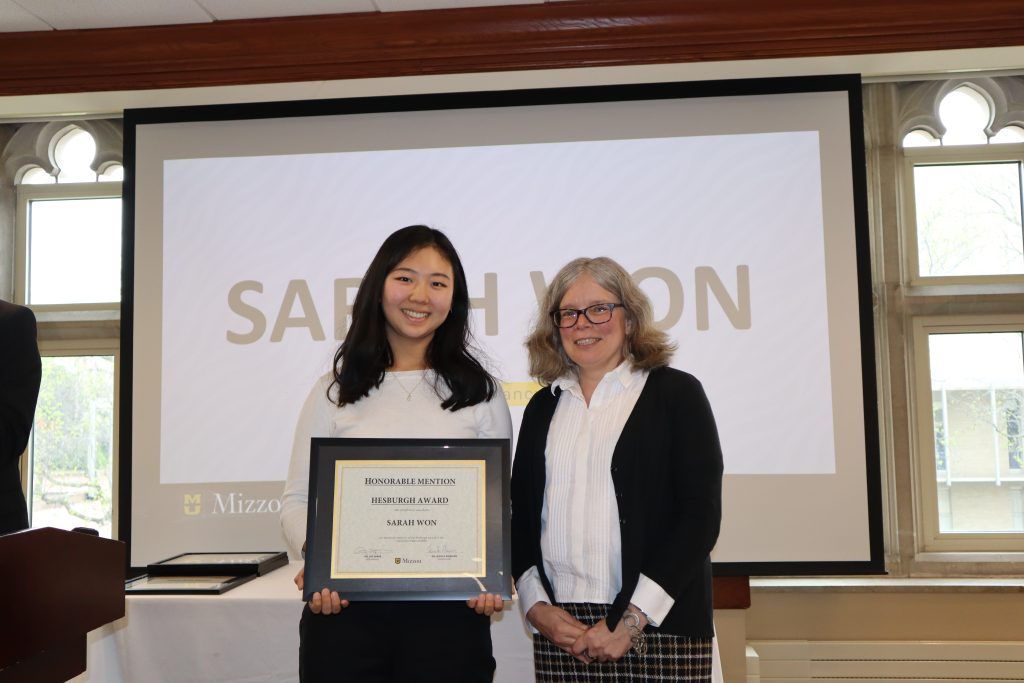 Sarah Won holding certificate at awards ceremony with Dr. Monnier.