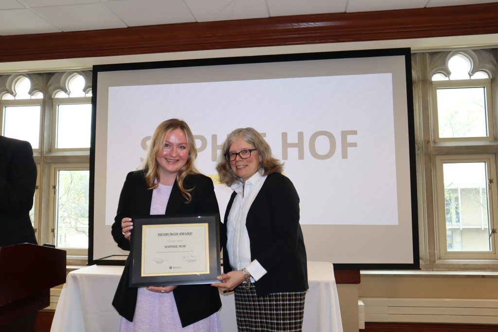 Sophie Hof holding certificate at awards ceremony with Dr. Monnier.