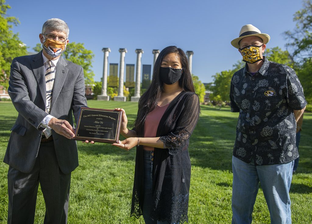 Jim Spain presents Hesburgh scholarship plaque to Alice Yu while William Horner stands by.