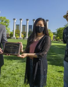 Jim Spain presents Hesburgh scholarship plaque to Alice Yu while William Horner stands by.